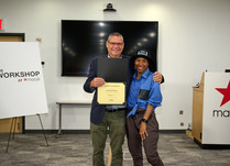 A man presenting a woman with a Certificate of Completion