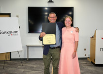 A man presenting a woman with an Uwila Warrior Certificate of Completion