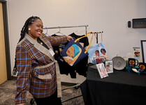 A woman showing off a bag and other products