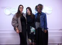 A group of 3 women pictured in front of a "celebrate" neon sign