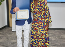 A man presenting a woman with a Besida Certificate of Completion