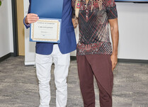 A man presenting a man with a Carlton Jones Certificate of Completion