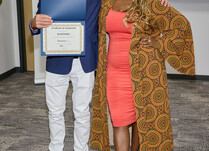 A man presenting a woman with a Kahindo Certificate of Completion
