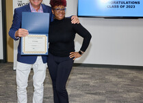 A man presenting a woman with an Ivyees Certificate of Completion