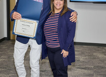 A man presenting a woman with a Nola Tawk Certificate of Completion