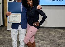 A man presenting a woman with an Observame Certificate of Completion