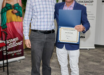 A man presenting a man with a Toa Waters Certificate of Completion