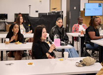 A workshop attendee with a microphone speaks during the workshop