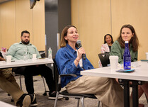 A workshop attendee with a microphone speaks during the workshop