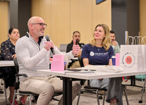 A workshop attendee with a microphone speaks during the workshop