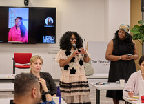 A workshop attendee with a microphone speaks during the workshop