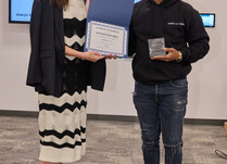 A woman presenting a man with a Manhattan Grey Certificate of Completion