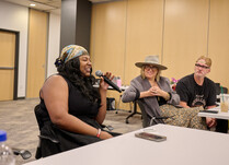 A workshop attendee with a microphone speaks during the workshop