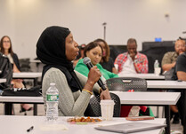 A workshop attendee with a microphone speaks during the workshop
