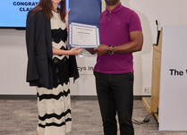 A woman presenting a man with a Jacob and John Certificate of Completion