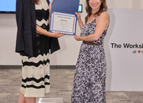 A woman presenting another woman with a Mightyly Certificate of Completion