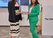 A woman presenting another woman with a Misayo House Certificate of Completion