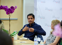 Conference attendees engaged in conversation around a table