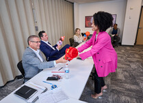 A woman handing out her product to workshop panel